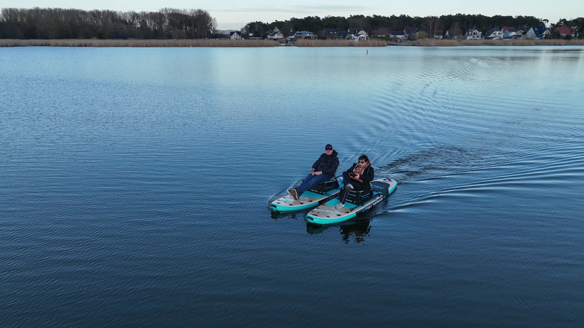 Zwei Personen auf einem mit SUPfix TWO gekoppelten Sitz-Katamaran auf dem See.